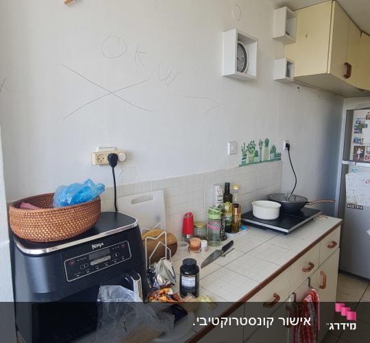 מטבח עם מכשירי חשמל וכלים על השיש